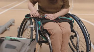 Kafkasyalı engelli bir kızın spor salonundaki sandalyeden sandalyeye kayışlarla bacaklarını bağladığı ve sonra badminton raketiyle kaçtığı görüntüler.