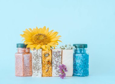 Doğal malzemelerden yapılmış organik el yapımı sabun ve mavi arka planda aromalı deniz tuzu. Tasarım için yaratıcı alan. 