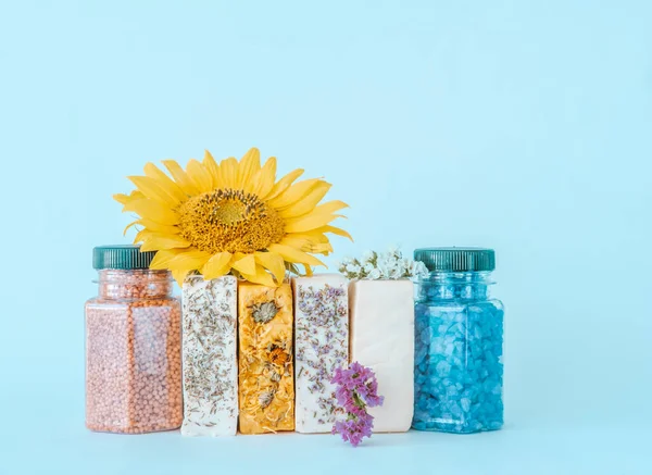 Doğal malzemelerden yapılmış organik el yapımı sabun ve mavi arka planda aromalı deniz tuzu. Tasarım için yaratıcı alan. 