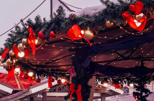 Christmas market kiosk with illumination, decorative red bows. Christmas Eve.