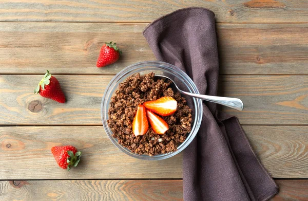 Gourmet Muesli with chocolate and strawberry on wooden background. Healthy breakfast.