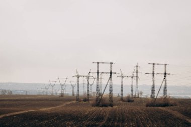 City power supply. Electricity flows through wires. High voltage towers in field