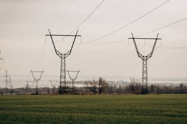 City power supply. Electricity flows through wires. High voltage towers in field