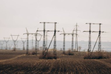 City power supply. Electricity flows through wires. High voltage towers in field