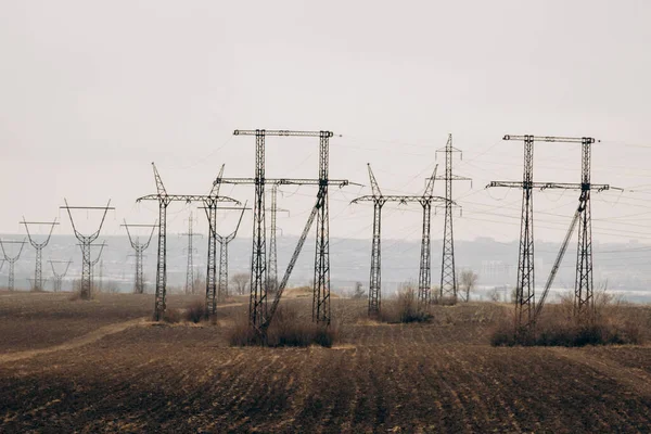 City power supply. Electricity flows through wires. High voltage towers in field