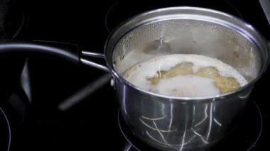 Buckwheat porridge is cooked in metal saucepan. Kitchen cooking food on induction cooker