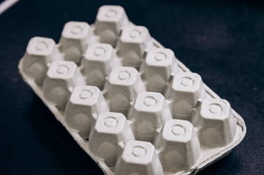 Paper cardboard box egg tray lies on table with demanding white eggs