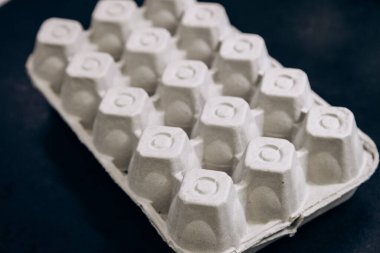 Paper cardboard box egg tray lies on table with demanding white eggs