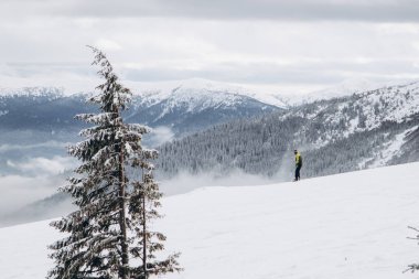 20.01.23 Dragobrat, Ukraine snowboarder rides ski lift in snow-covered mountains of Carpathians