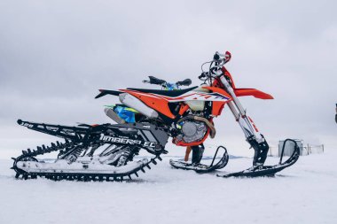 Moto snowmobile stands on snow high in mountains