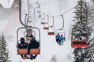 20.01.23 Dragobrat, Ukraine snowboarder rides ski lift in snow-covered mountains of Carpathians