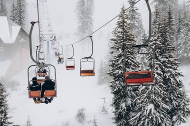 20.01.23 Dragobrat, Ukraine snowboarder rides ski lift in snow-covered mountains of Carpathians