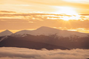 Dragobrat, Ukraine mountain landscape with fog and fir trees. Dawn in a snowy ski resort