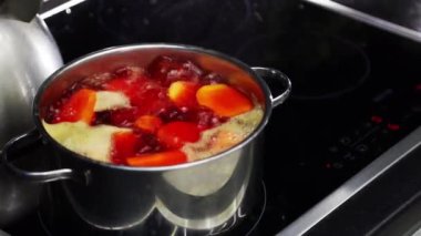 Boiling water in a saucepan on an electric stove. Boiled red beetroot in an iron pan