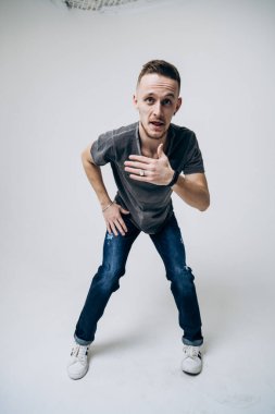 Adam beyaz arka planda duruyor ve salsa yapıyor. Tam boy bachata koçu.