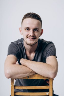 Gri tişörtlü adam doğrudan kameraya bakıyor. Erkek portresi. Cilt sorunları. Saç dökülmesi