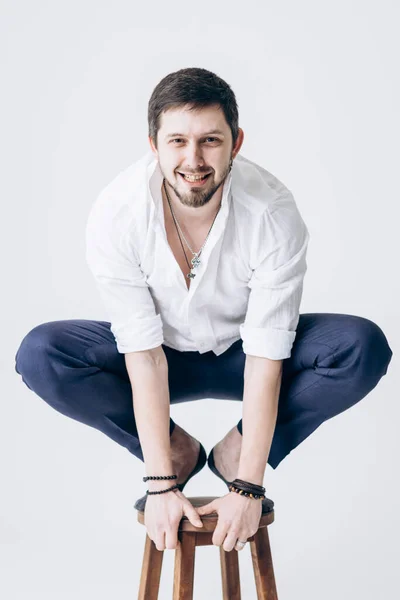 stock image Portrait of handsome man with beard in white shirt sits on chair