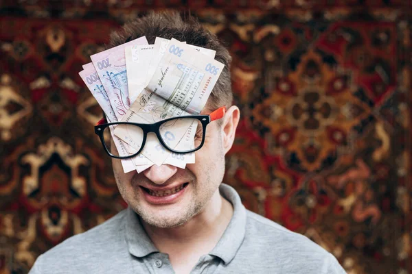 stock image Man with glasses and Ukrainian money inside them. Startup. New business, brilliant idea for a million. Hryvnia in large bills