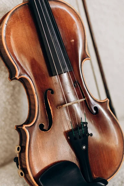 木製の茶色のバイオリンは白いソファにあります ヴァイオリニスト用楽器 — ストック写真