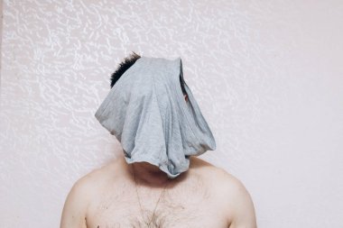 Çıplak göğüslü adam kafasına gri iç çamaşırı geçirmiş. Zihinsel ve sağlık sorunları