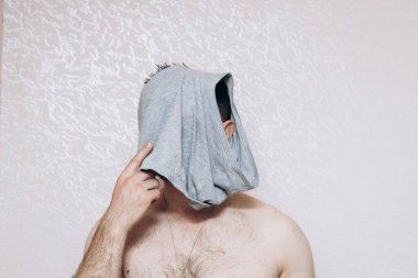 Çıplak göğüslü adam kafasına gri iç çamaşırı geçirmiş. Zihinsel ve sağlık sorunları