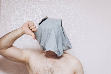 Çıplak göğüslü adam kafasına gri iç çamaşırı geçirmiş. Zihinsel ve sağlık sorunları