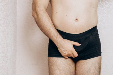 Kıyafetsiz bir adam elinde kayıp bir muz tutuyor. Ereksiyon sorunu, erkek sağlığı