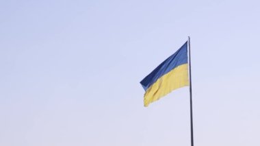 Ukrayna 'nın sarı-mavi bayrağı açık bir günde mavi bulutsuz gökyüzüne karşı rüzgarda dalgalanıyor
