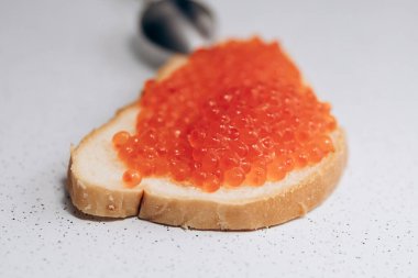 Masada kırmızı havyarlı sandviç var. Kilo vermek için sağlıklı beslenme Ekmek ve somon havyarı