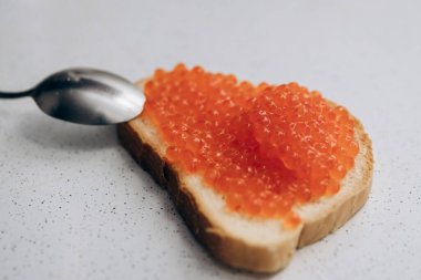 Masada kırmızı havyarlı sandviç var. Kilo vermek için sağlıklı beslenme Ekmek ve somon havyarı