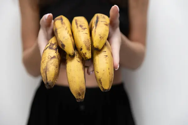 女人的手捧着一堆发黑的香蕉 早上健康饮食 免版税图库图片