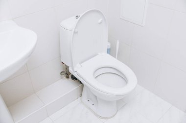 Açık kapaklı beyaz tuvalet. Tuvalet sabah prosedürleri