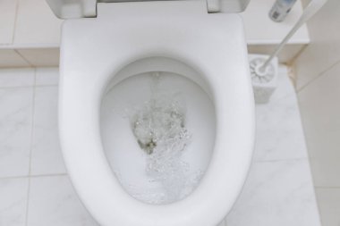 Açık kapaklı beyaz tuvalet. Tuvalet sabah prosedürleri