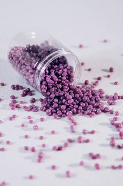 Masanın üzerine granül şeklinde mor kaş cilası saçılmış. Kozmetoloji, kaş uzmanı.