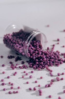 Masanın üzerine granül şeklinde mor kaş cilası saçılmış. Kozmetoloji, kaş uzmanı.