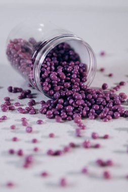 Masanın üzerine granül şeklinde mor kaş cilası saçılmış. Kozmetoloji, kaş uzmanı.