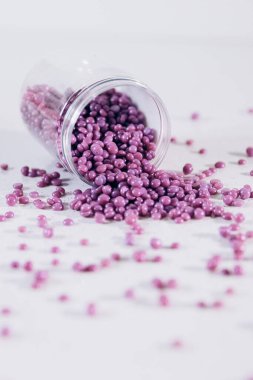 Masanın üzerine granül şeklinde mor kaş cilası saçılmış. Kozmetoloji, kaş uzmanı.