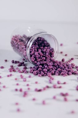 Masanın üzerine granül şeklinde mor kaş cilası saçılmış. Kozmetoloji, kaş uzmanı.