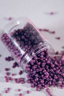 Masanın üzerine granül şeklinde mor kaş cilası saçılmış. Kozmetoloji, kaş uzmanı.