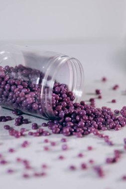 Masanın üzerine granül şeklinde mor kaş cilası saçılmış. Kozmetoloji, kaş uzmanı.