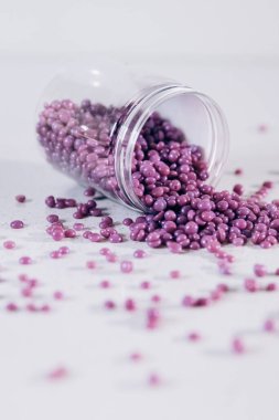 Masanın üzerine granül şeklinde mor kaş cilası saçılmış. Kozmetoloji, kaş uzmanı.