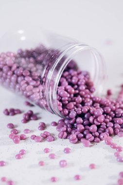 Masanın üzerine granül şeklinde mor kaş cilası saçılmış. Kozmetoloji, kaş uzmanı.