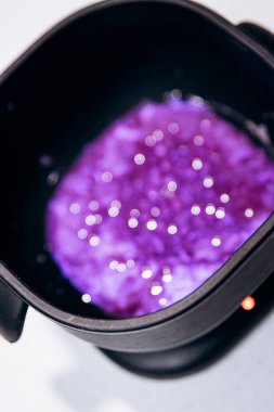 Purple granules are heated in black wax melter. Eyebrow tools clipart