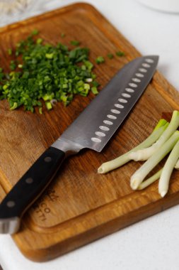 Mutfak bıçağı ve taze soğanlı yemek. Yemek pişiriyorum.