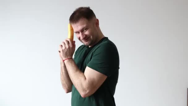 Homem Segura Banana Suas Mãos Como Pistola Tolos Redor Câmera — Vídeo de Stock