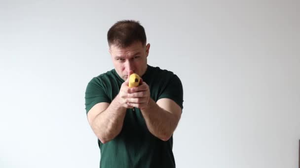 Homem Segura Banana Suas Mãos Como Pistola Tolos Redor Câmera — Vídeo de Stock