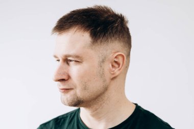 Yeşil tişörtlü neşeli Avrupalı genç adam kameranın önünde duygularını gösteriyor.