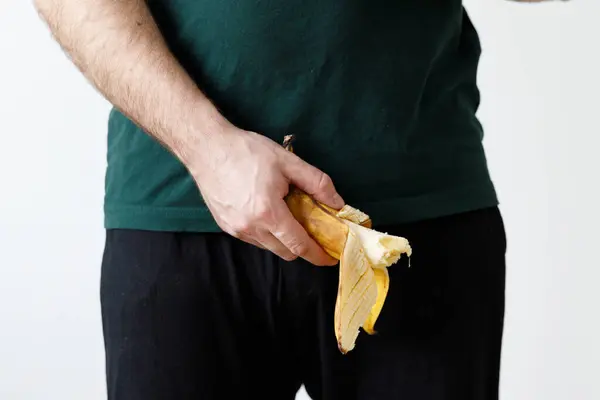 Man is holding banana. Men\'s health, impotence, potency