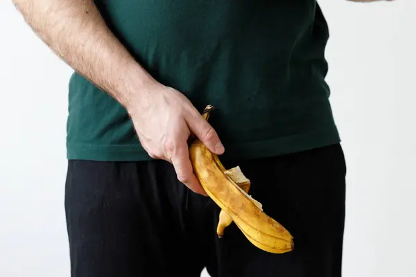 Man is holding banana. Men\'s health, impotence, potency