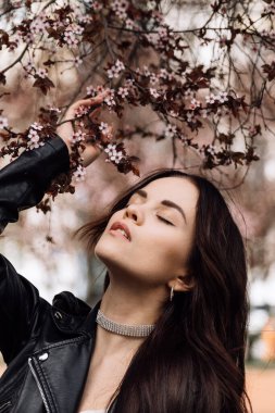 Çiçek açan ağaçta güzel bir kızın fotoğrafı çekiliyor.